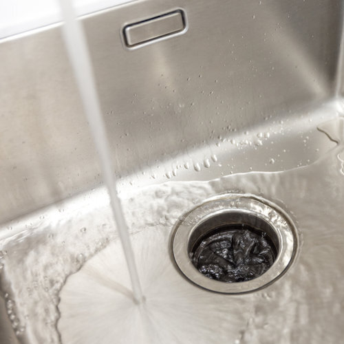 Stainless kitchen sink with food waste disposal in modern home